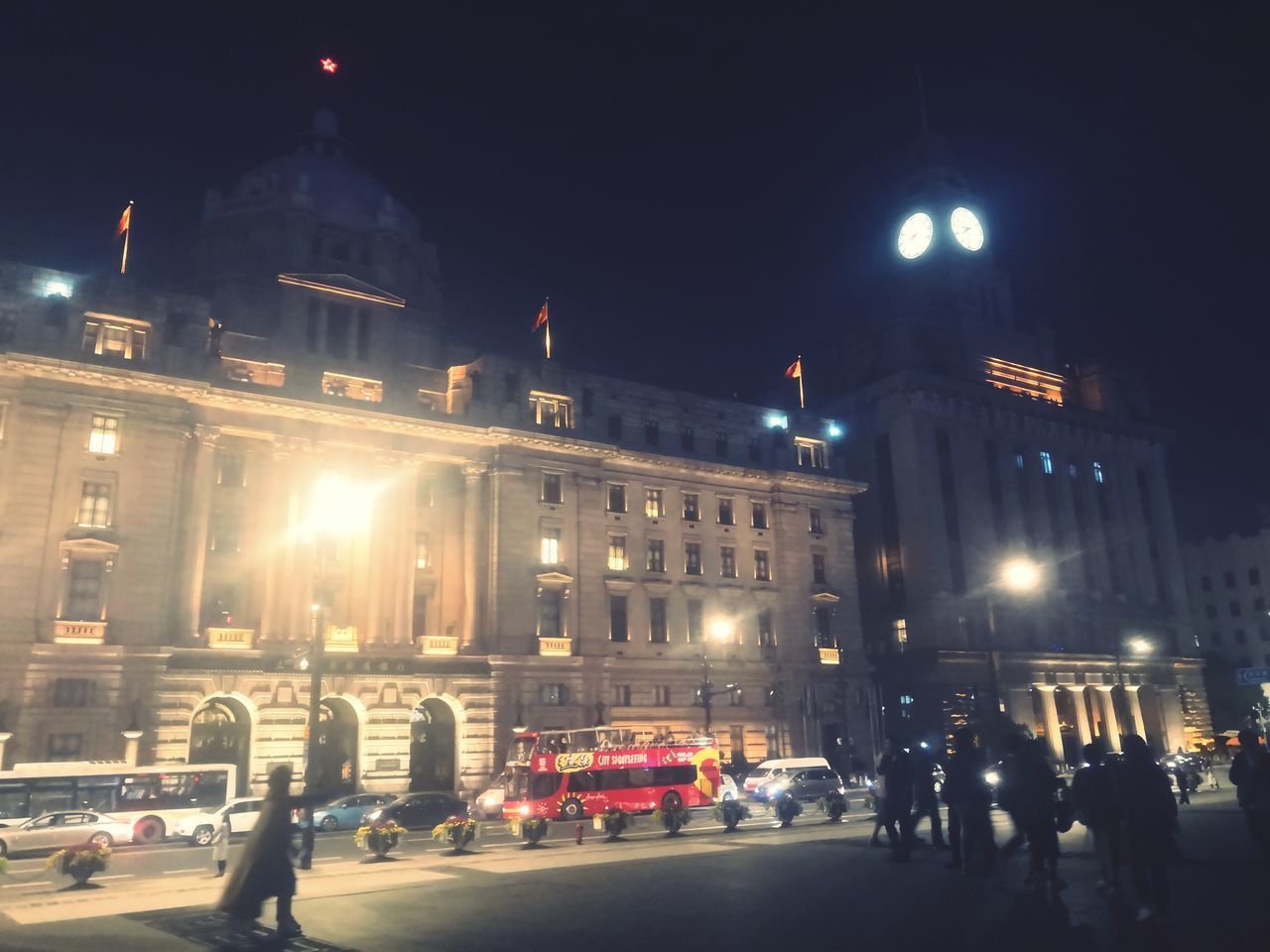 PEOPLE ON ILLUMINATED CITY STREET AT NIGHT