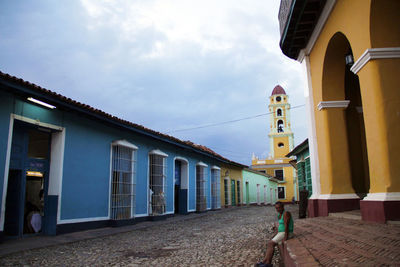 Street amidst buildings in town against sky