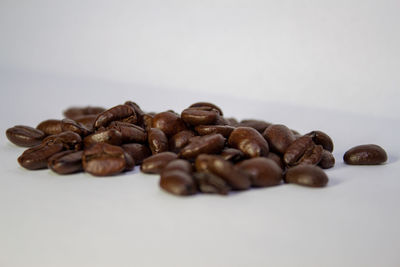 Close-up of roasted coffee beans against white background