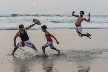 FULL LENGTH OF MEN RUNNING ON BEACH