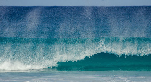 Close-up of waves splashing on sea against sky