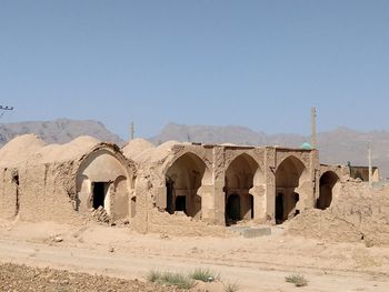 Old building in desert against clear sky