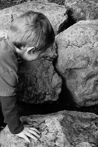 Boy lying on rock