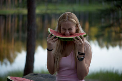 Young woman biting into watermelon