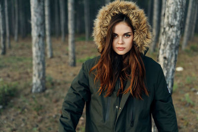 Portrait of beautiful young woman standing in forest