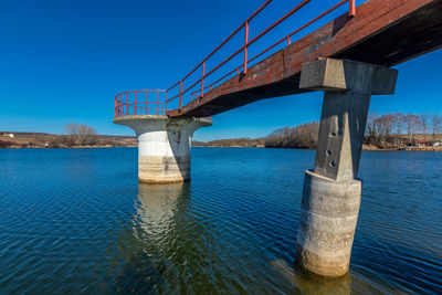 Bridge over river against blue sky