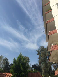 Low angle view of trees and buildings against sky