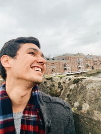 Portrait of young man looking away against sky