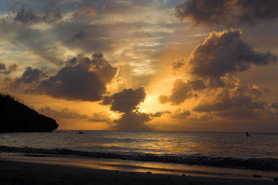 Scenic view of sea against dramatic sky during sunset