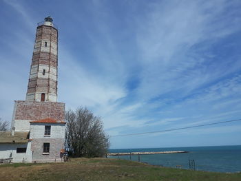 Tower by sea against sky