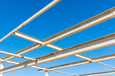 Low angle view of power lines against blue sky