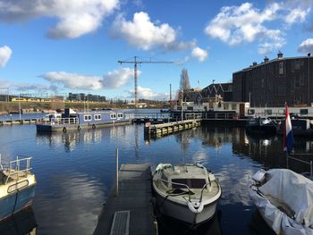 Boats moored at harbor in city