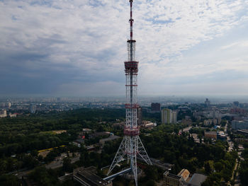 Aerial view of buildings in city against cloudy sky