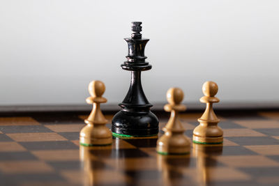 Close-up of game pieces on chess board against gray background