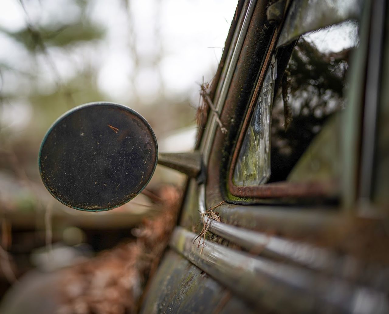 CLOSE-UP OF OLD RUSTY CAR ON METAL