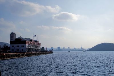 Scenic view of sea against sky in city