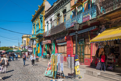 People on street market against buildings in city