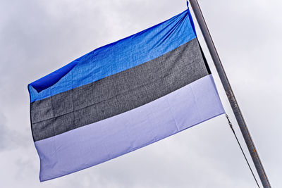 Low angle view of flag against blue sky