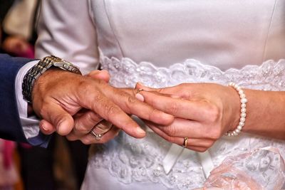 Midsection of hands with wedding rings