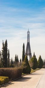 Tower amidst trees and buildings against sky