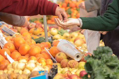 Midsection of woman taking money at market stall