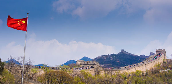 Flag by great wall of china against sky 