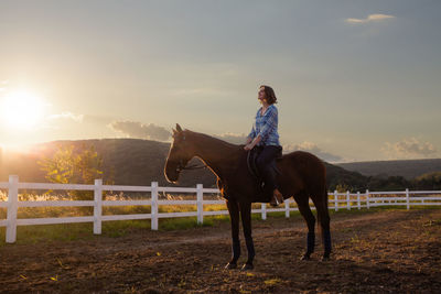 Full length of woman riding horse against sky