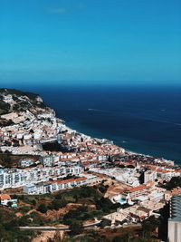 High angle view of townscape by sea against sky