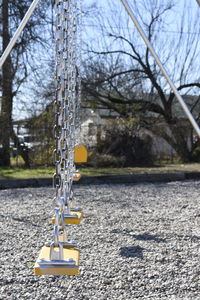 Close-up of swing against bare trees