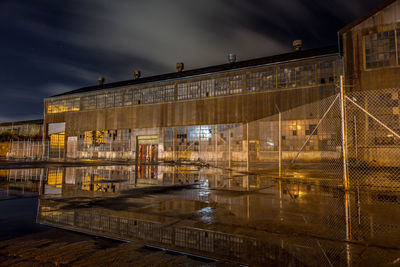 Illuminated building against cloudy sky at dusk