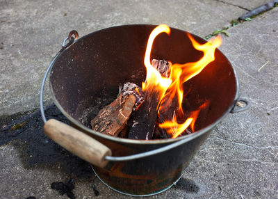 Do it yourself backyard bbq grill in a bucket with sausages and potatoes