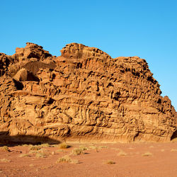 View of rock formations in desert against clear blue sky