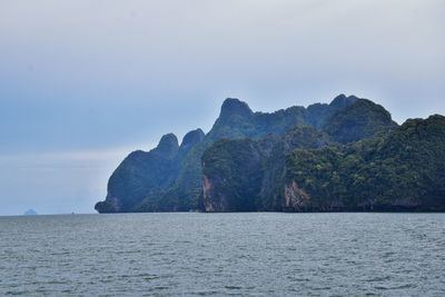 Rock formations by sea against sky