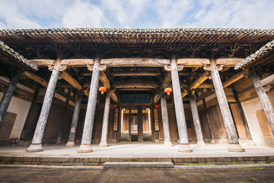 Low angle view of old building against cloudy sky