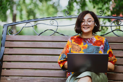Female professional enjoys remote work on a calm sunny day in a lush green park