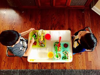 High angle view of girl sitting on table