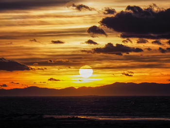 Scenic view of sea against romantic sky at sunset