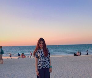 Friends on beach against clear sky