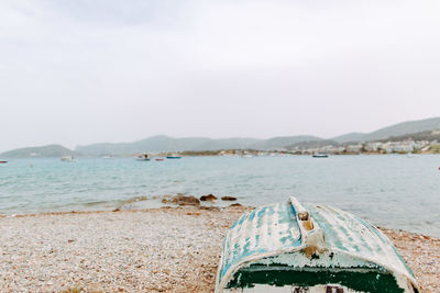 Close-up of sea by beach against sky