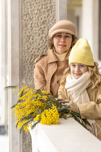 A mother and daughter with mimosa bouquet in spring park. international women's day march 8