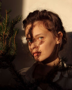 Close-up portrait of woman against wall at home