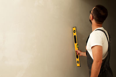 Rear view of man standing against wall