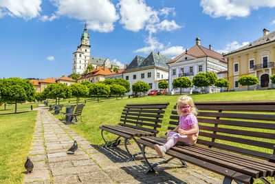 Rear view of woman sitting on railing