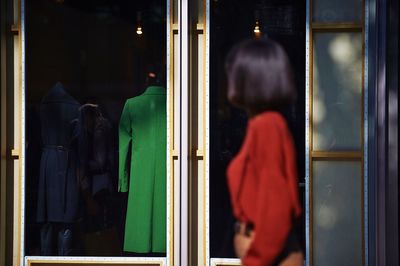 Side view of woman looking at window display