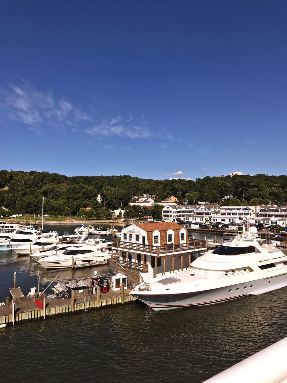 nautical vessel, built structure, architecture, water, transportation, building exterior, mode of transport, moored, outdoors, day, waterfront, blue, sea, sky, harbor, nature, yacht, tree, no people