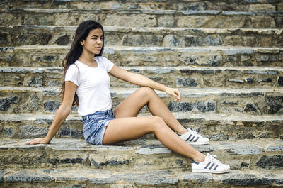 Portrait of smiling young woman sitting on steps