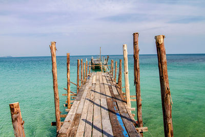 Wooden posts on beach against sky