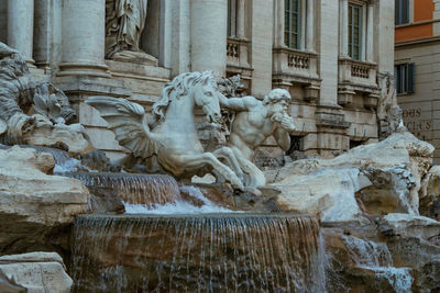 Statue of fountain in front of building