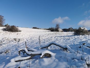 Scenic view of snow covered field against sky