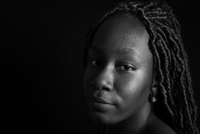 Low angle view of young woman against black background